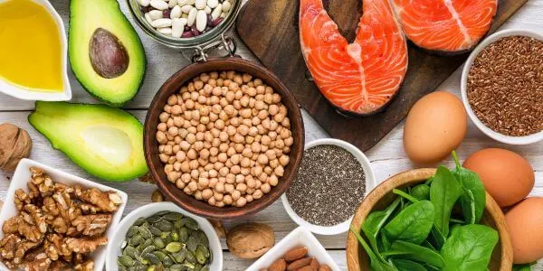 Voeding bij vermoeidheid: zalm, eieren, spinazie, kikkererwten, avocado, walnoten en zaden met ijzer, vitamine B12 en omega 3